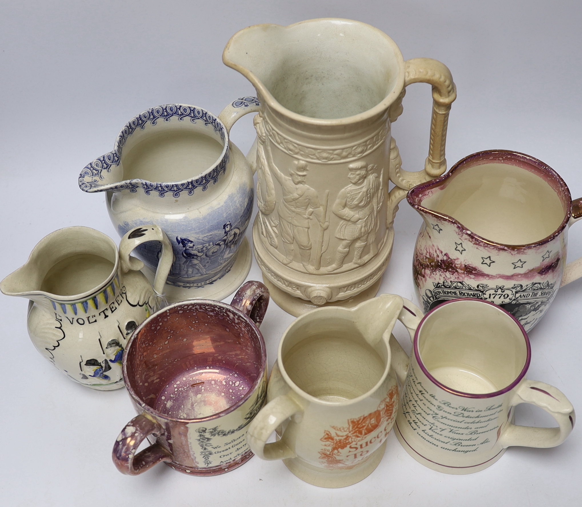 Seven military and naval themed jugs including a Leeds creamware jug 'Loyal Volunteers' inscribed 'L Volnteers' c.1803, an early 19th century success to the volunteers jug, a Sunderland pink splash lustre loving cup etc.